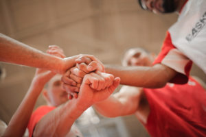 Team putting their hands together in support of goal