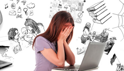 women with head in hands over laptop surrounded by worries