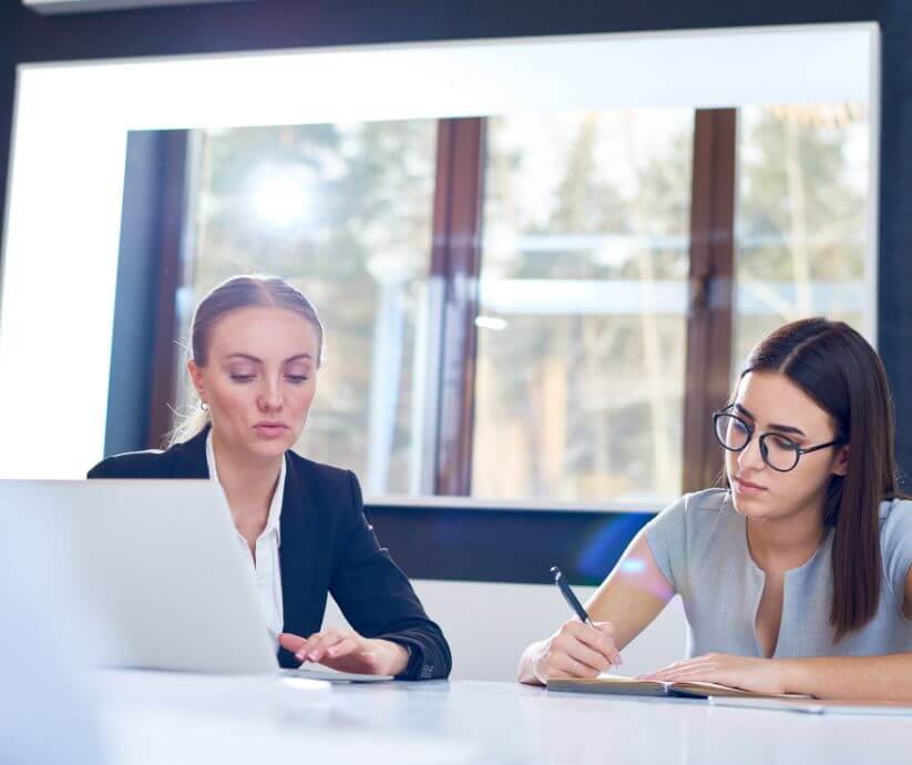 two women in a meeting one is coaching the other to be a better leader