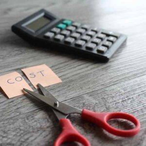 Scissors cutting a note with cost in it, money moves to control the finances in your business